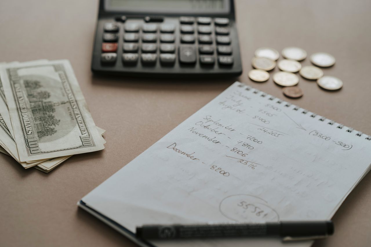 services-03 Desk setup showing calculator, cash, coins, and financial notes for budgeting.
