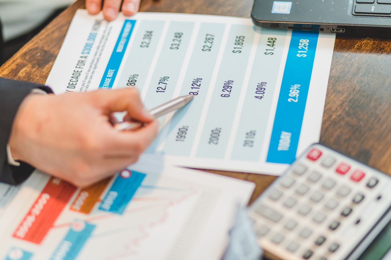 why-choose-us Close-up of financial documents with charts and a calculator used for business analysis.